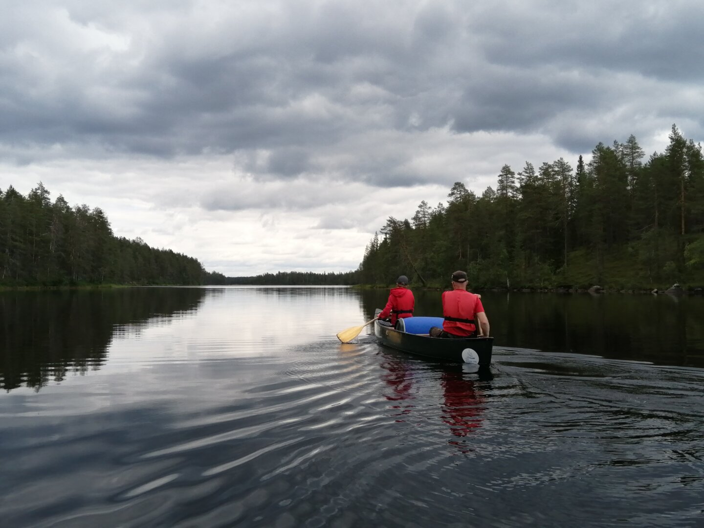 An adult and a child canoeing on an open Indian canoe